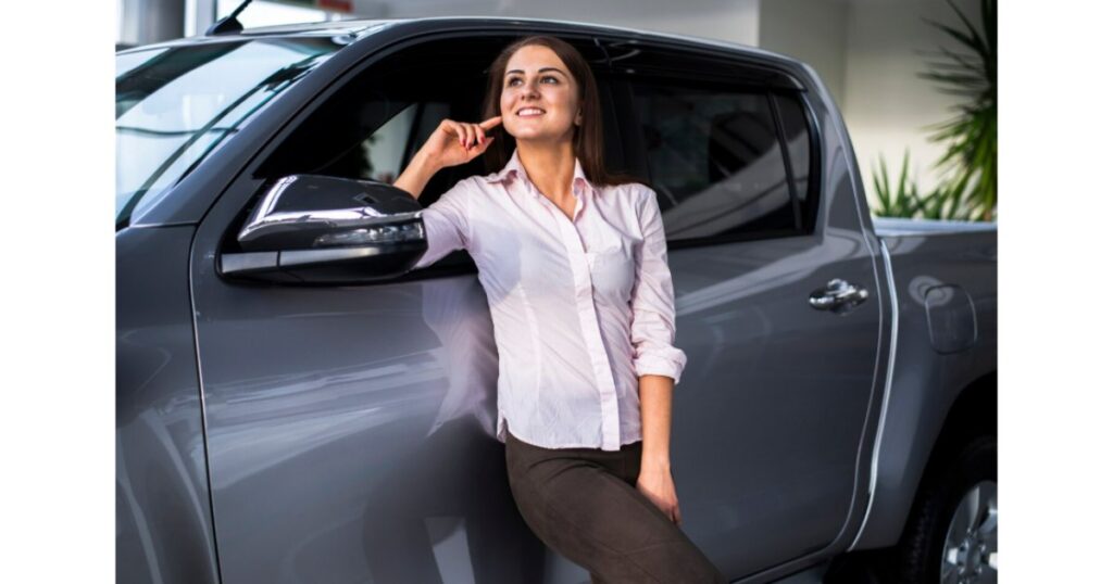 Mujer profesional apoyada en pickup gris doble cabina, solución de movilidad empresarial con renting de Total Fleet Costa Rica