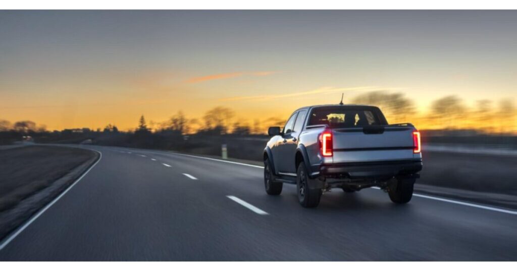 Vista trasera de pickup doble cabina en carretera al atardecer, representando la libertad operativa del renting empresarial con Total Fleet Costa Rica