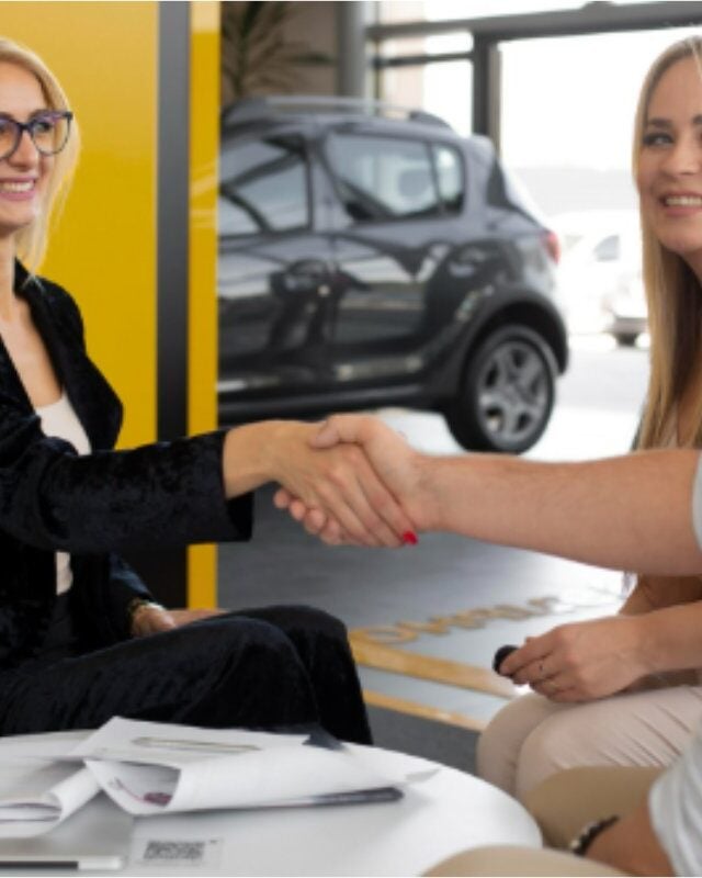 Firma de contrato en concesionario con cliente feliz