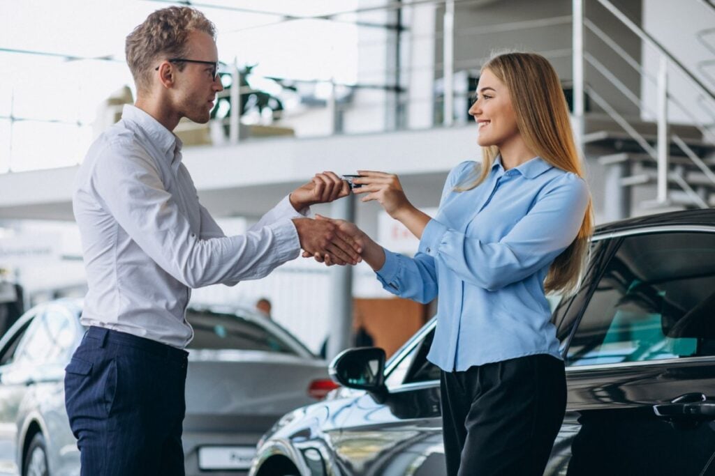 Entrega de llaves entre cliente y vendedor en concesionario